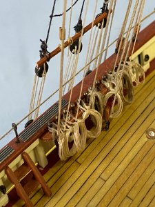 Coiled ropes at pin rails at main starboard side